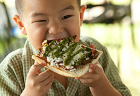 child enjoying farm pizza